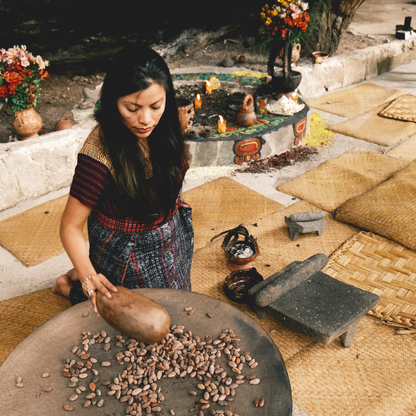 Hand-grinding cacao nibs on a traditional stone metate Mayan cacao artisan in Guatemala, 100% Chocolate, Cocoa